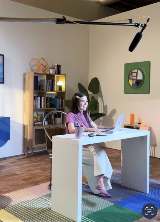 Natalia grabando una clase en un estudio, con su laptop y un micrófono