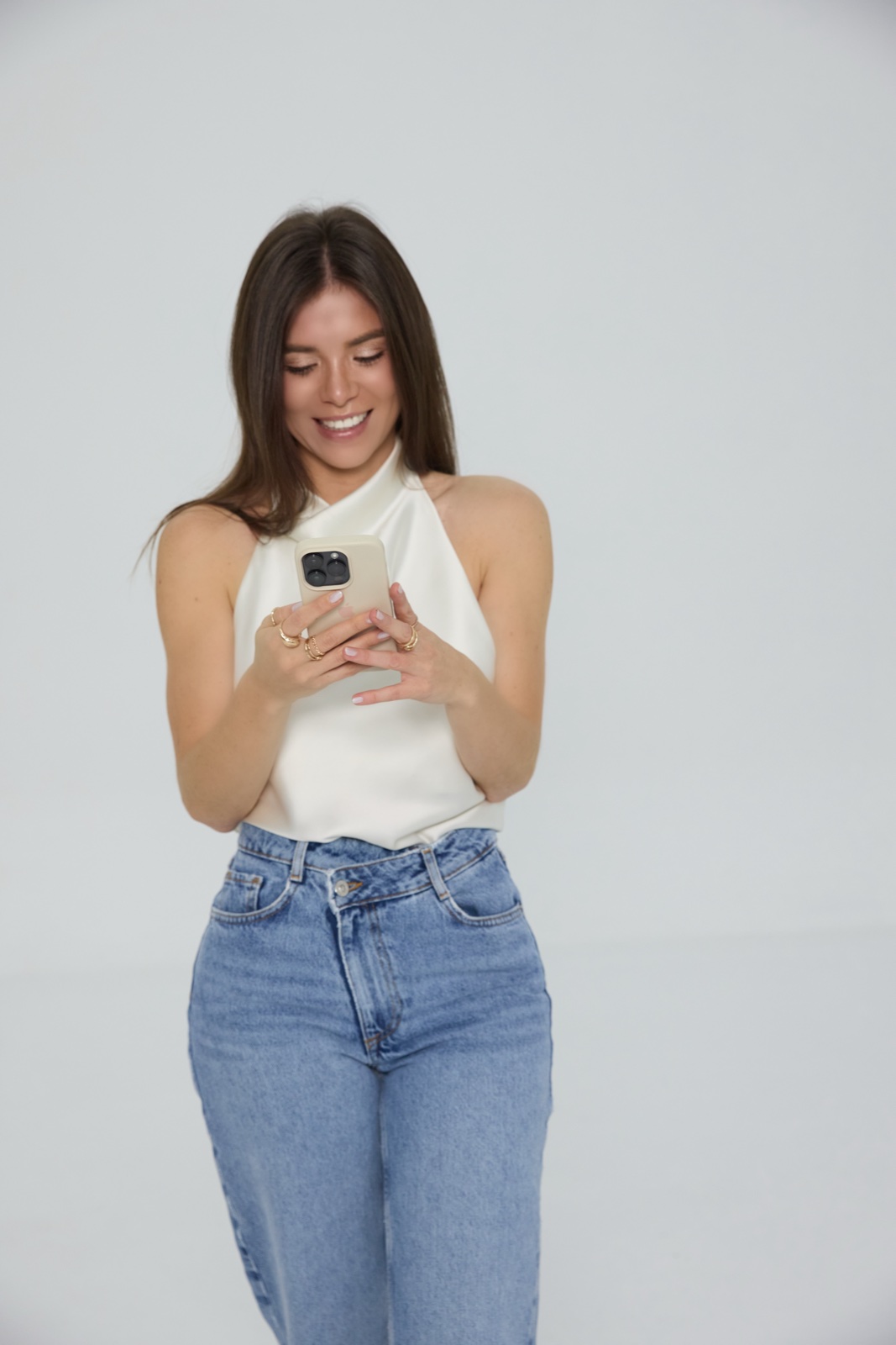 Natalia sonriendo mientras mira su celular